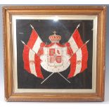 An early 20th century silk embroidered panel depicting the coat of arms for the King of Spain,