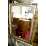 A reproduction gilt composition framed and bevelled wall mirror,