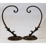A pair of early 20th century iron brackets, each having scrolling arm to a pierced circular base, h.
