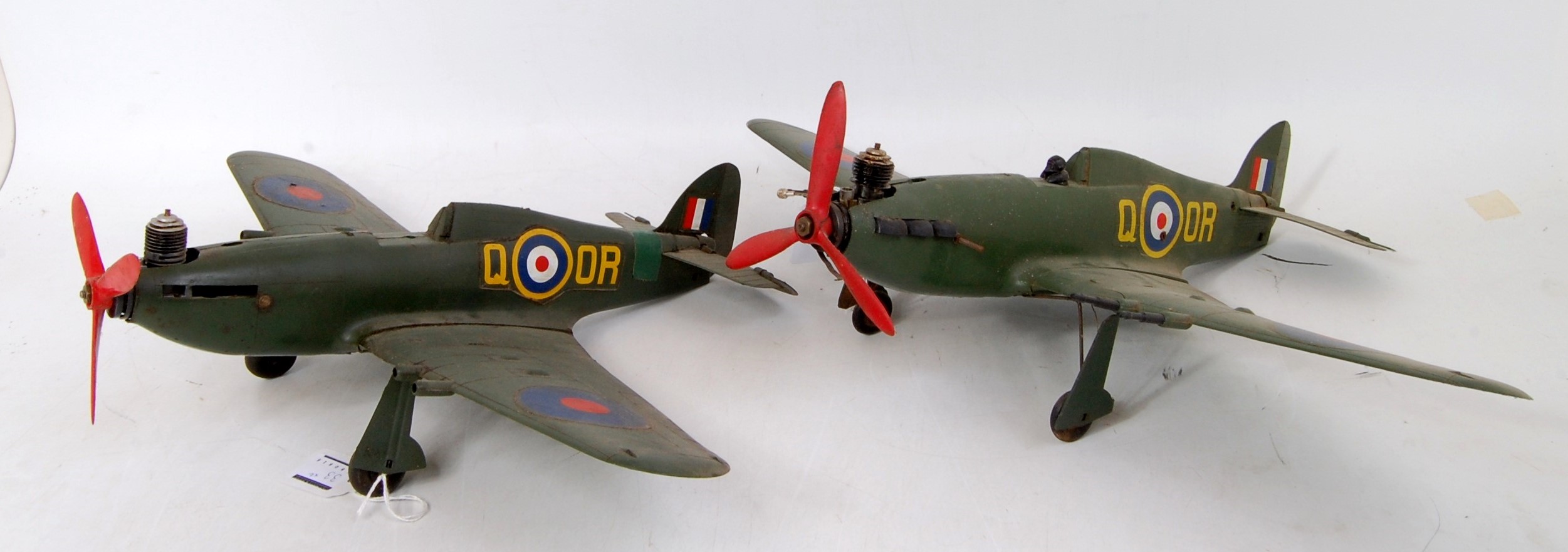 A pair of plastic petrol powered miniature model aircraft in the form of Supermarine Spitfires,