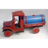 An early 20th century wooden and pressed metal model of a water carrying lorry finished in red and