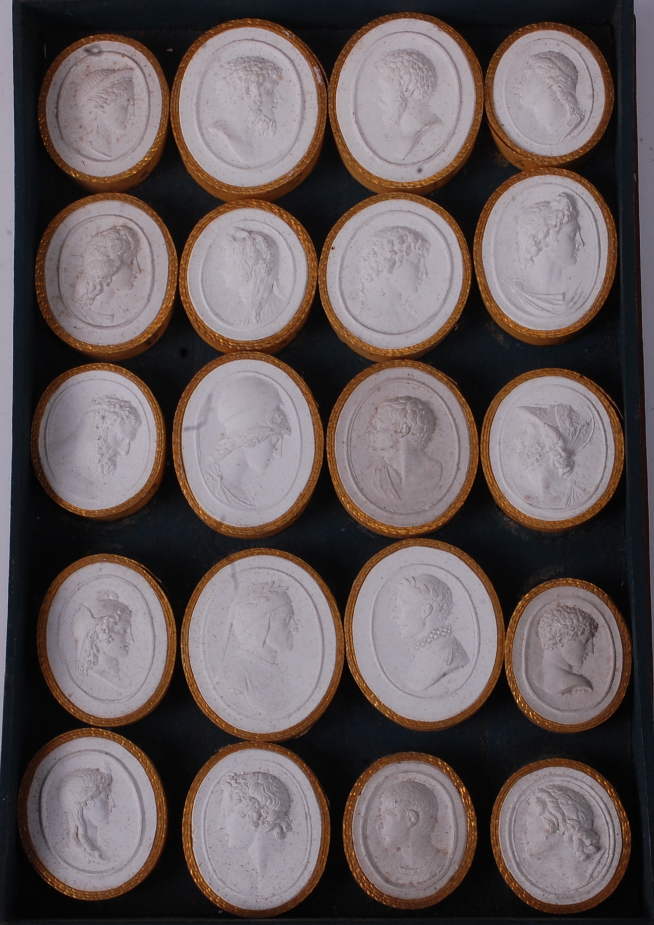 A collection of twenty Italian Grand Tour plaster intaglios, being profile portrait medallions,
