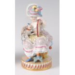 A Meissen porcelain figure of a seated girl in her boudoir, with attendant lap-dog,