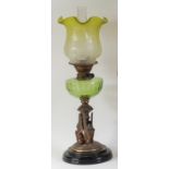 A late Victorian bronzed metal oil lamp, having green tinted acid etched shade, green glass font,