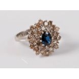 An 18ct sapphire and diamond cluster ring, the oval sapphire, approx. 6.5 x 5.