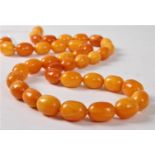 A butterscotch amber bead necklace, the roughly uniform oval amber beads, approx.