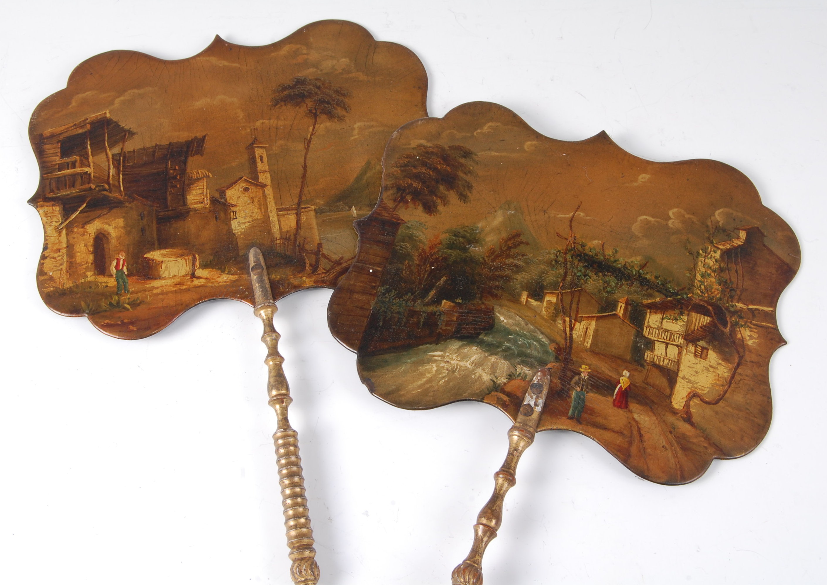 A pair of 19th century lacquered face-screens, each depicting Continental figure landscape scenes,