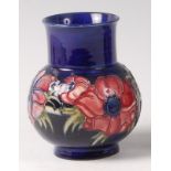 An early 20th century Moorcroft pottery squat vase in the Anemone pattern, of lower bulbous form,