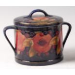 An early 20th century Moorcroft pottery circular twin handled biscuit barrel and cover in the