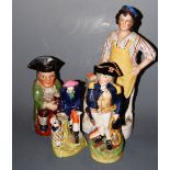An early 19th century pearlware toby jug with triform hat and in seated pose with green jacket and