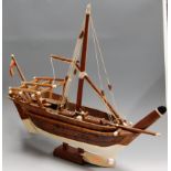 A scratch-built wooden model of a sailboat