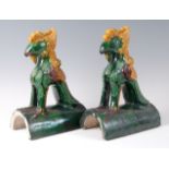 A pair of Chinese majolica glazed stoneware ridge tiles, each surmounted with a four-claw dragon, h.