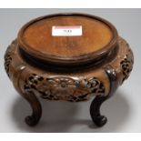 An early 20th century Chinese hardwood vase stand of squat circular form the frieze fret carved