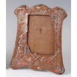 An Art Nouveau embossed silver plated easel photograph frame, of shaped outline,