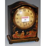 A 1920s black lacquered and chinoiserie decorated mantel clock having an engine turned dial with