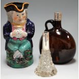 A Staffordshire toby jug with typical triform hat and in seated pose with blue jacket and green