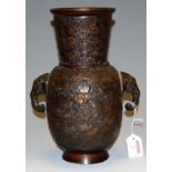 A Chinese bronze vase having tapering neck to baluster body having twin elephant mask handles and