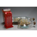 A ship in a bottle on stand; together with one other; and a boxed telephone box savings bank (3)