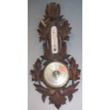 A late Victorian carved oak cased barometer