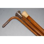 A Victorian walking cane, having a mallacca shaft and ivory tip; together with two other walking