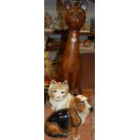 An extremely large carved hardwood figure of a seated cat, h.80cm; together with two pottery figures