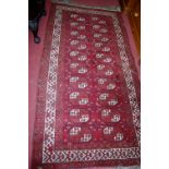 A Persian woollen red ground bokhara rug, 222x117cm