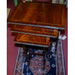 A reproduction mahogany nest of three occasional tables