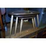 An Ercol dark elm nest of three pebble tables, the largest width 65cm
