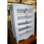 A contemporary white washed chest of drawers having glass inset panels, width 65.5cm