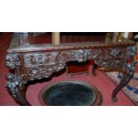 An early 20th century Chinese carved walnut writing table having a raised superstructure, width