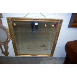 A modern gilt framed bevelled square wall mirror