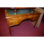 An Edwardian mahogany and satinwood inlaid gilt tooled leather four drawer writing table, width