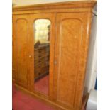 A Victorian figured walnut round cornered triple wardrobe, having central mirrored door, w.190cm