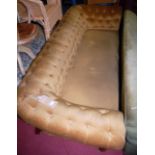 A Victorian mahogany framed and mustard upholstered buttonback three-seater Chesterfield on turned