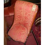 A mid-Victorian mahogany framed and red floral upholstered nursing chair