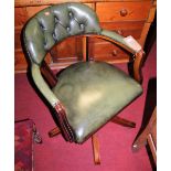 A contemporary mahogany green leather buttoned and further studded tub revolving desk chair