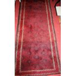 A Persian woollen red ground hall runner, having complex field and trailing borders, 275 x 97cm