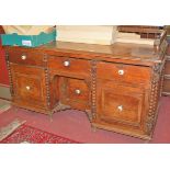 An Aesthetic Movement joined oak and elm kneehole writing desk, having three-quarter raised