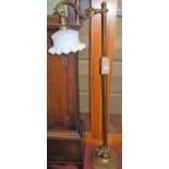 A Victorian style brass standard lamp, having milk glass handkerchief shade to single branch arm,