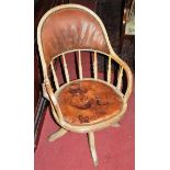 An early 20th century limed oak tan leather and studded tub revolving desk chair