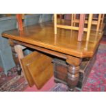 A late Victorian oak extending dining table, having wind-out action and two extra drop-in leaves,