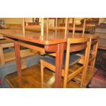 A 1960s English teak extending dining table, having pull-out action and single fold-out leaf, max.