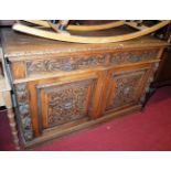 A late 19th century heavily carved oak double door side cupboard, width 153cm