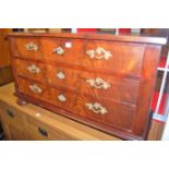 A 19th century Continental mahogany and flame mahogany low chest of three long drawers raised on bun