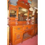 A late Victorian relief carved oak mirrorback sideboard, having three bevelled mirrorplates over