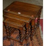 An oak nest of three occasional tables, raised on barleytwist turned supports