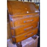 A 1930s moulded oak slopefront three drawer writing bureau, w.76cm