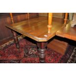 An Edwardian walnut extending dining table, having single drop-in leaf