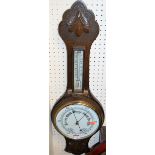 An early 20th century carved oak aneroid two dial wheel barometer