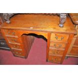 A Victorian stained pine kneehole writing desk fitted with eight short drawers, width 108cm